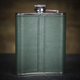 green whiskey flask on a black surface